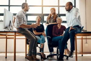 group of employees talking at work discussing workplace culture problems.